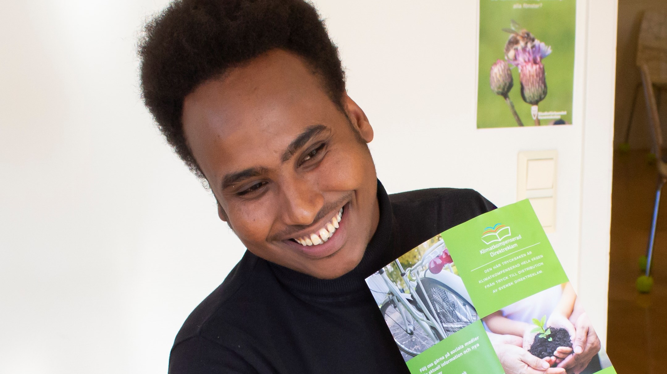 Faraah Mohamud ler och håller upp en broschyr.