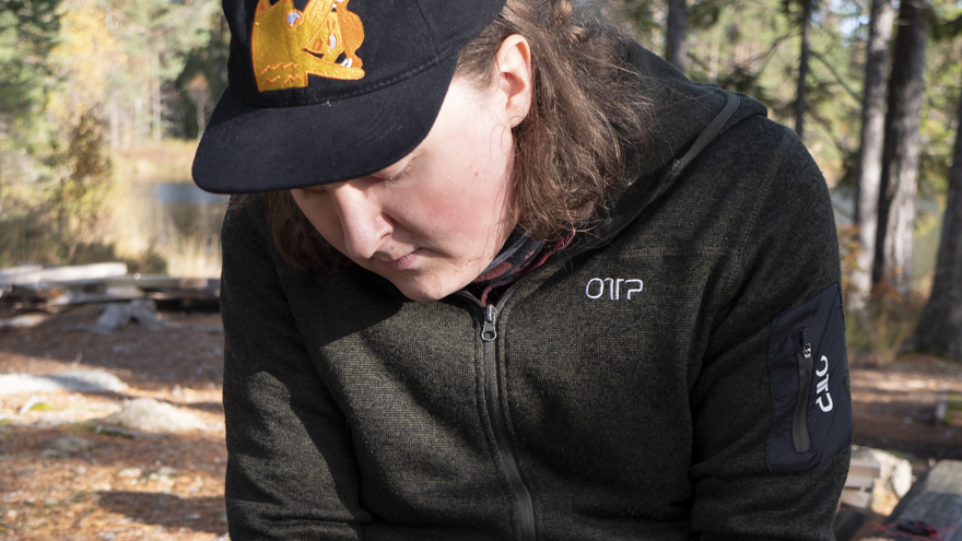 En deltagare på Allmän kurs Friluftsliv täljer en tändpinne.