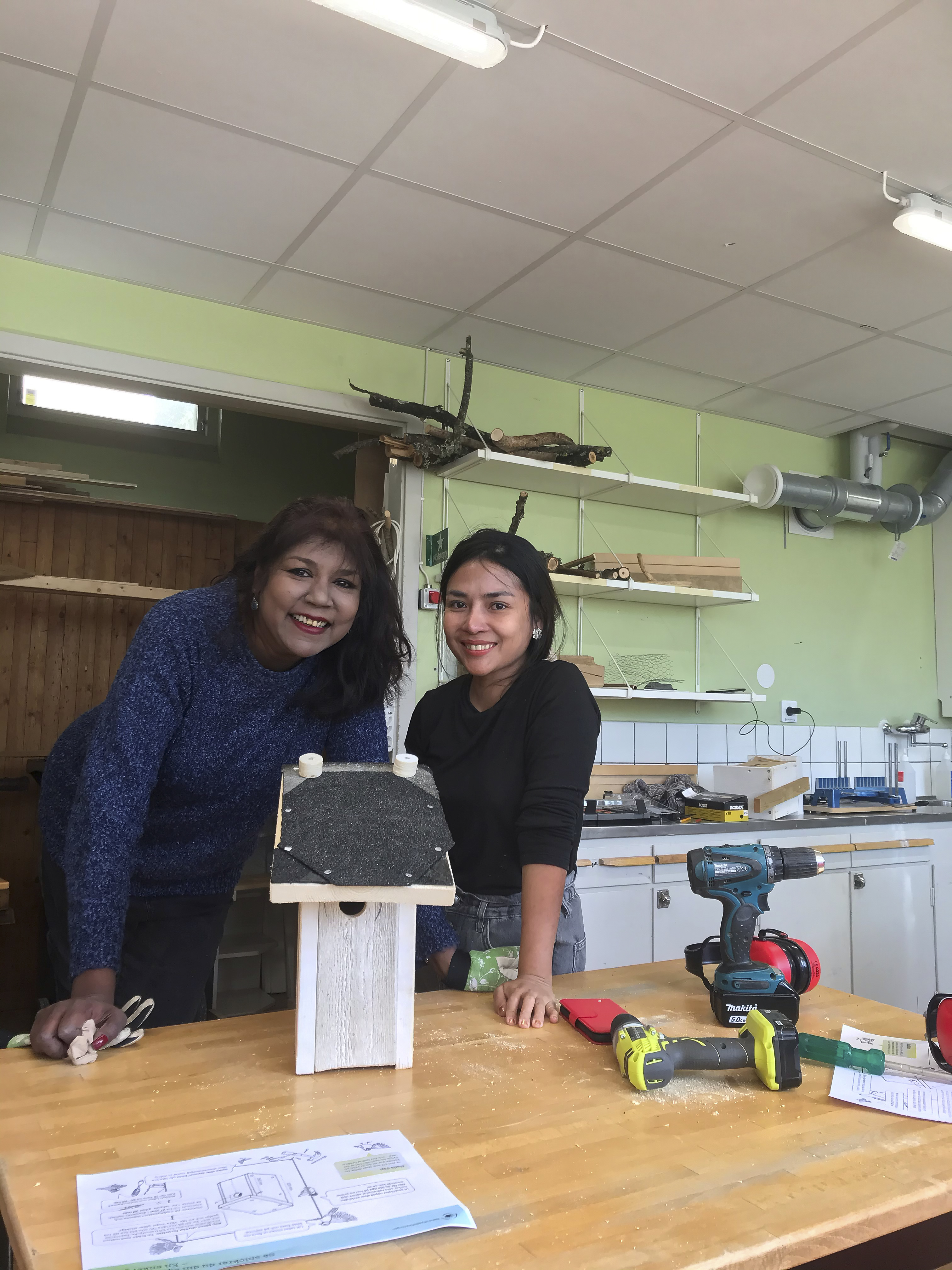 Två deltagare visar upp sin fågelholk, som är byggd av spillvirke