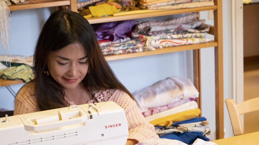 En deltagare som syr på en symaskin