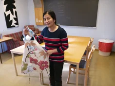 En folkhögskoledeltagare visar upp ett förkläde, som är skapat av en gammal gardin.