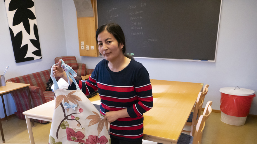 En folkhögskoledeltagare visar upp ett förkläde, som är skapat av en gammal gardin.