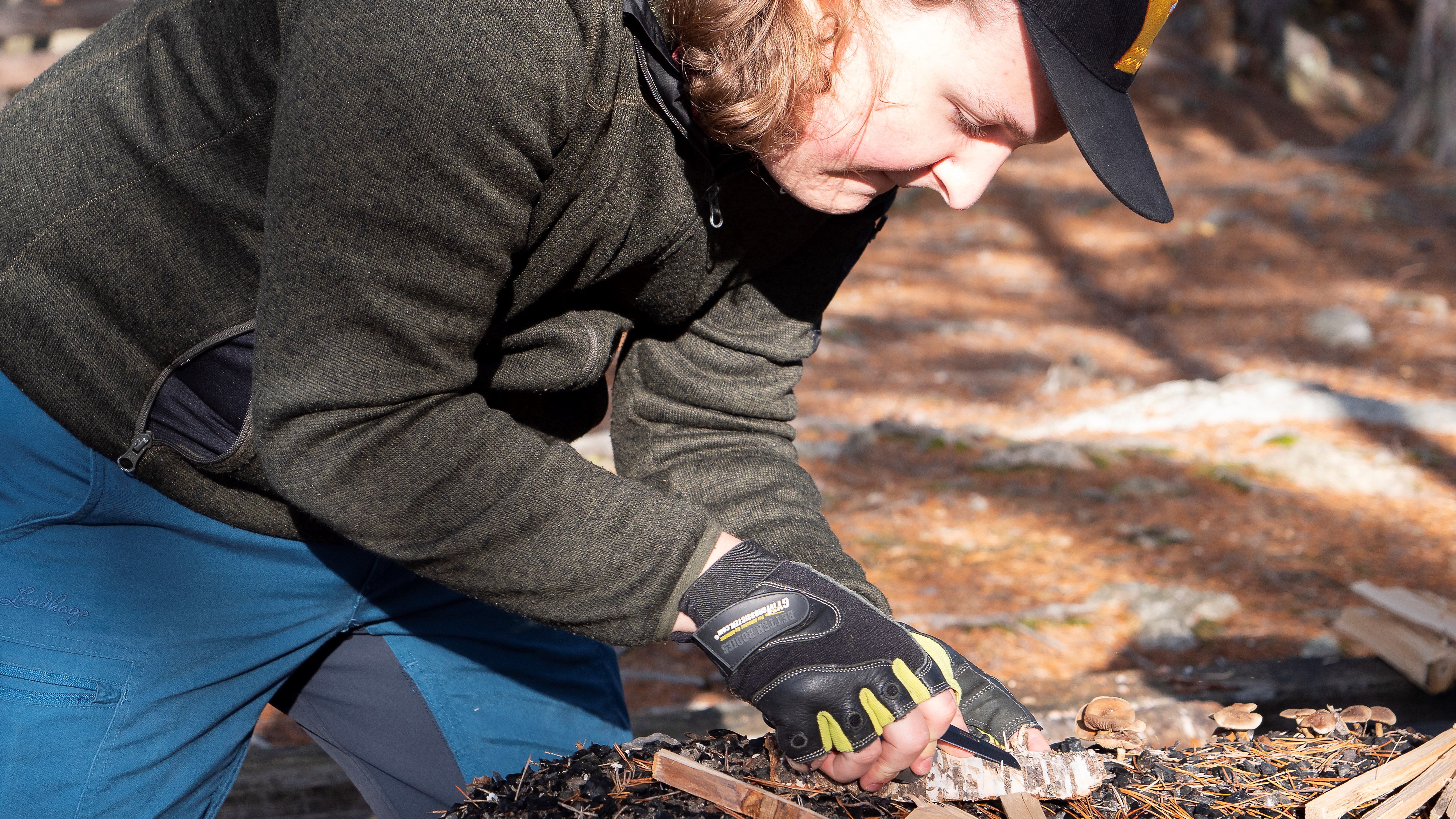 En deltagare på Allmän kurs Friluftsliv förbereder en tändpinne för att kunna göra upp eld utomhus.