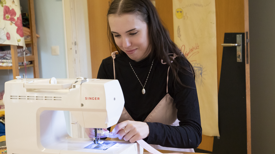 En deltagare som syr på symaskin