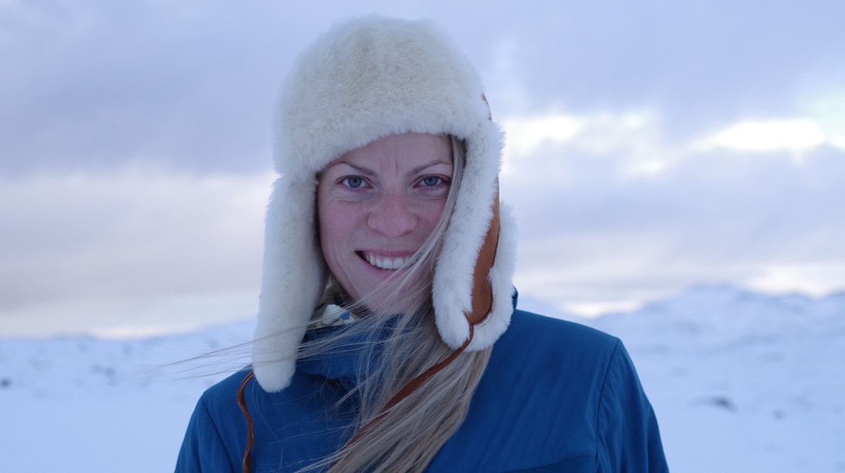 Porträttbild på äventyraren Gina Johansen i ett snöigt landskap.