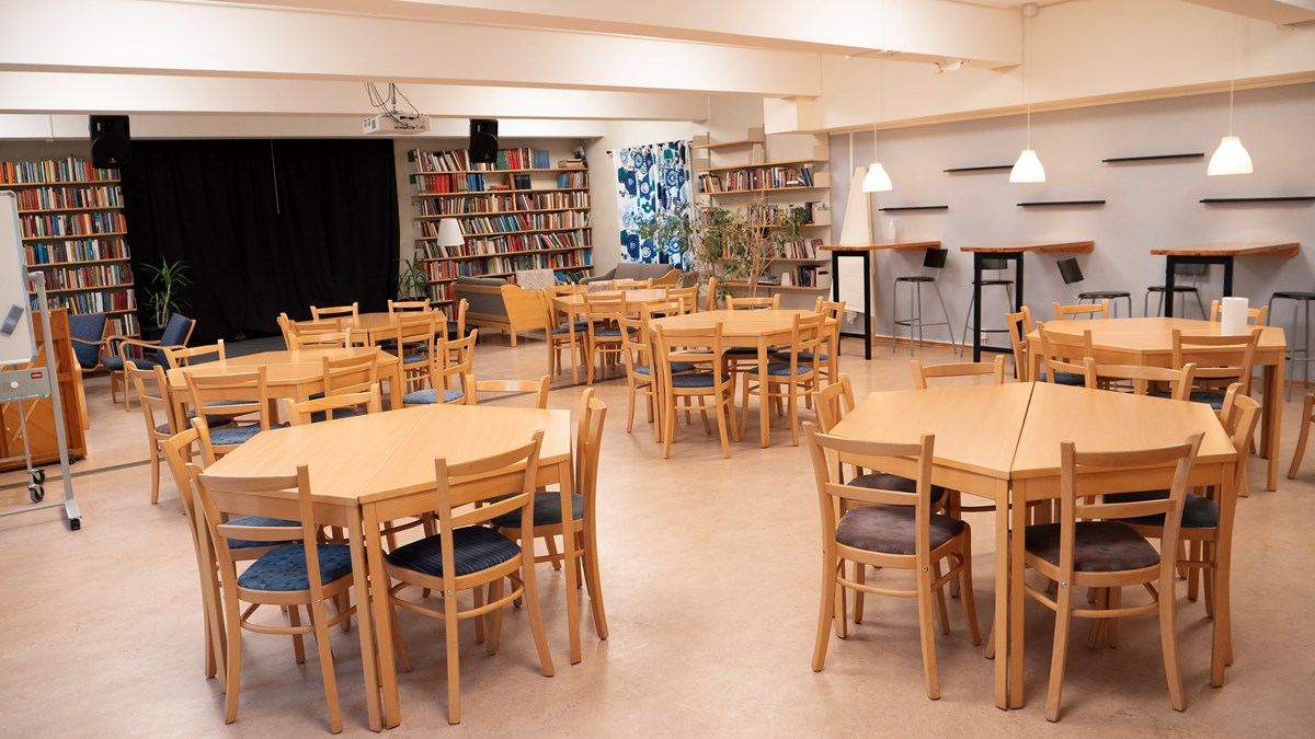 Bibliofiket på Dalslands folkhögskola i Färgelanda. På bilden syns ett antal bokhyllor, en scen samt sex bordsgrupper med sex platser vardera.