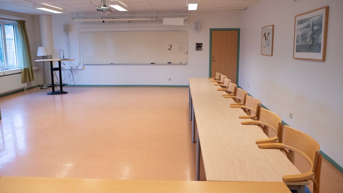 Nybo konferenslokal. På bilden syns en whiteboard samt bord med sju stycken stolar upphängda.