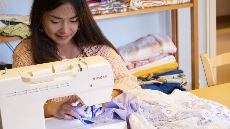 En deltagare som syr på en symaskin