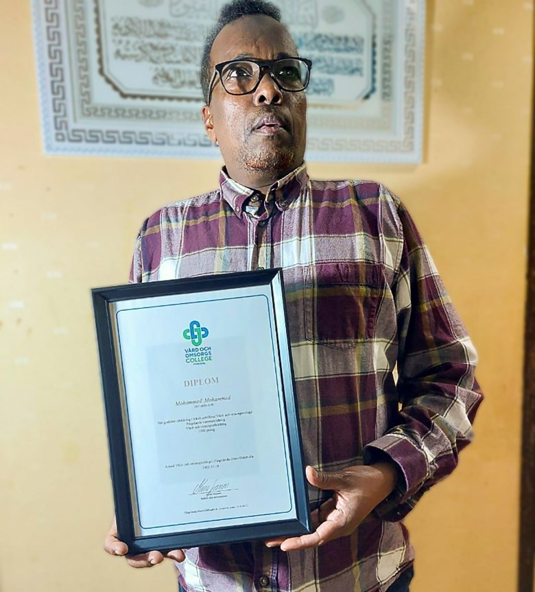 Mohammed Mahamud med sitt undersköterskediplom.