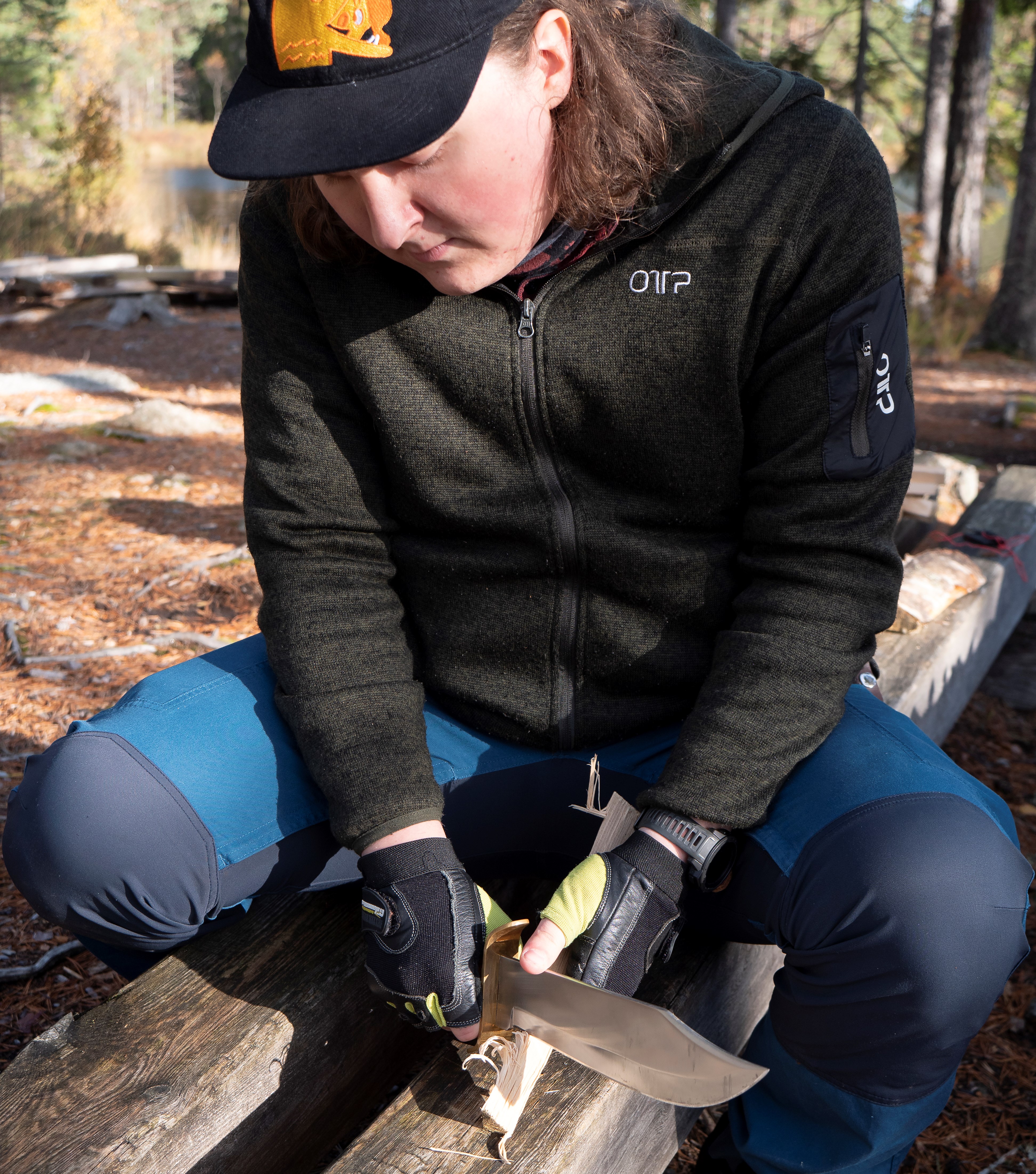 En deltagare på Allmän kurs Friluftsliv täljer en tändpinne.