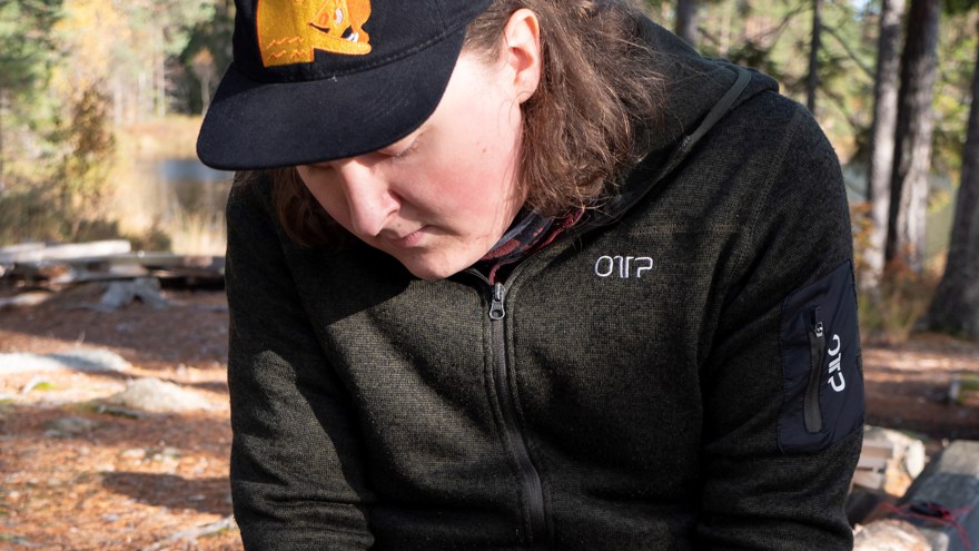 En deltagare på Allmän kurs Friluftsliv täljer en tändpinne.