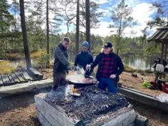 Tre personer lagar mat på en stekhäll