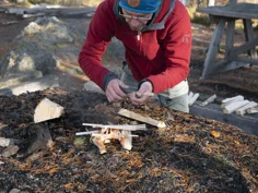 Läraren på Allmän kurs Friluftsliv gör upp en eld utomhus.