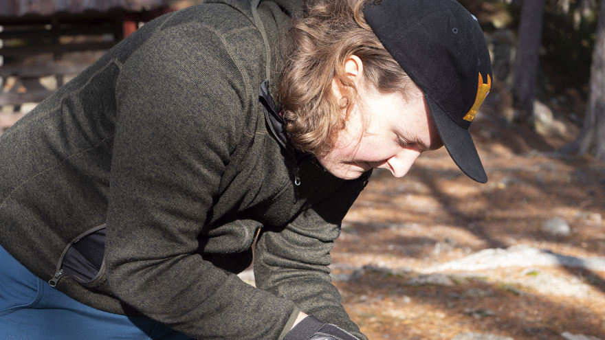 En deltagare förbereder en tändpinne för att kunna göra upp eld utomhus.