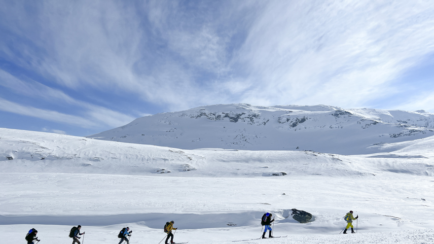 Sex personer som åker turskidor i fjällen.