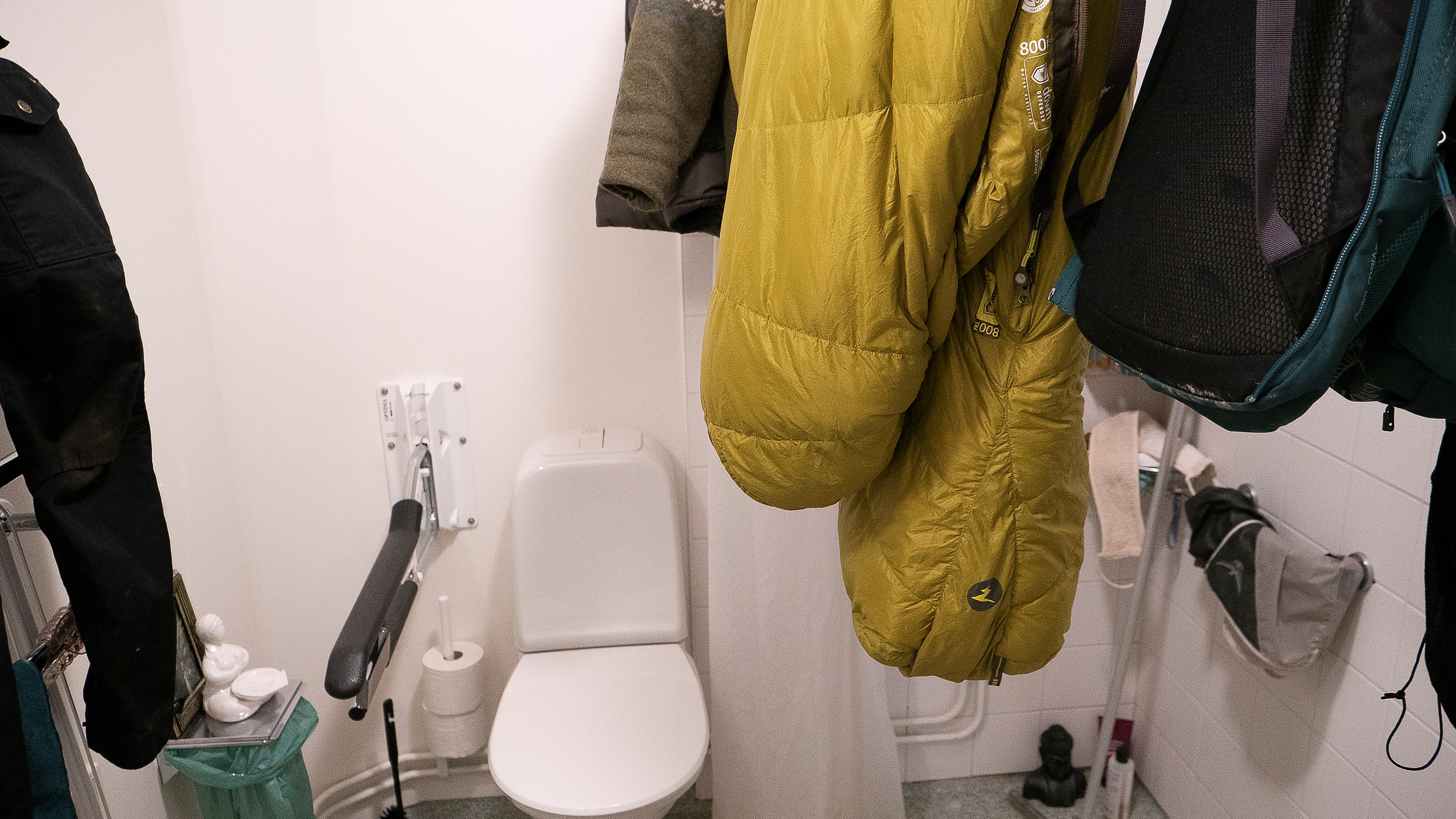 Ett badrum med friluftsutrustning som hänger på tork.