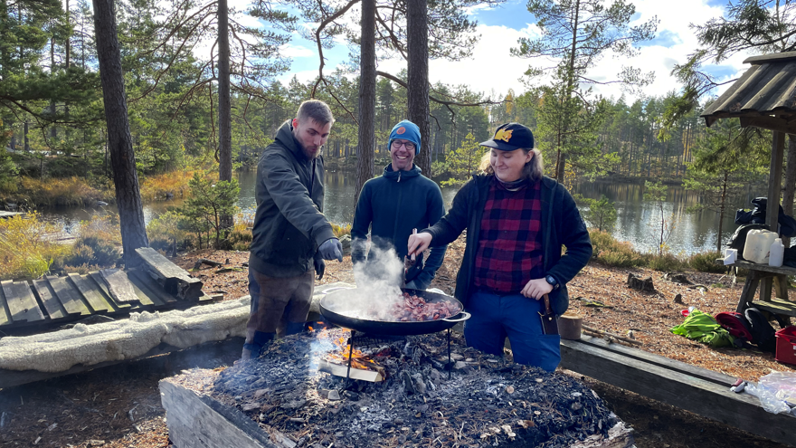 Tre personer lagar mat på en stekhäll
