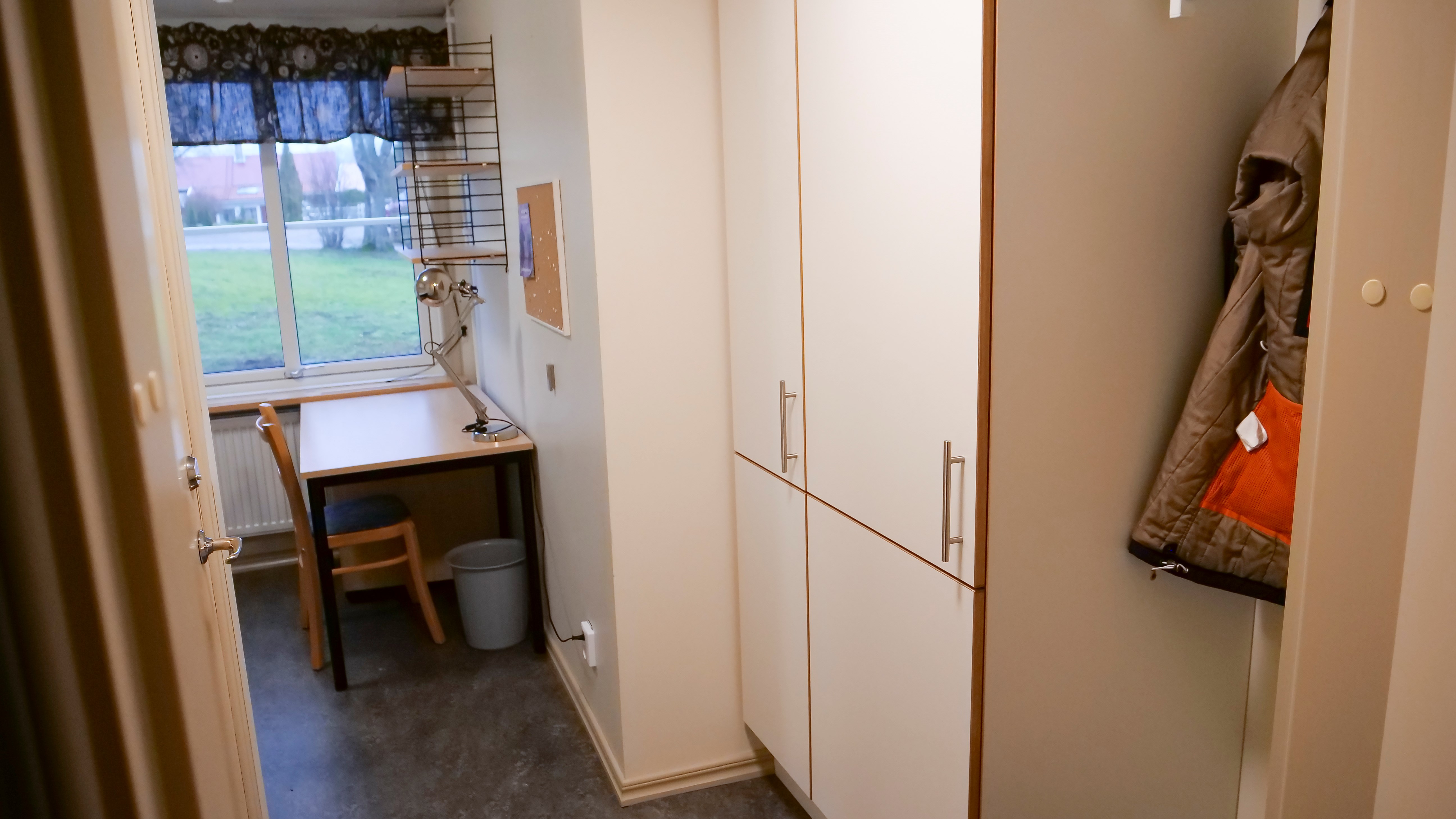 Litet internatrum, Gråbo, Dalslands folkhögskola i Färgelanda. Ett skrivbord framför ett fönster med en hylla ovanför samt fyra garderober och en hatthylla.