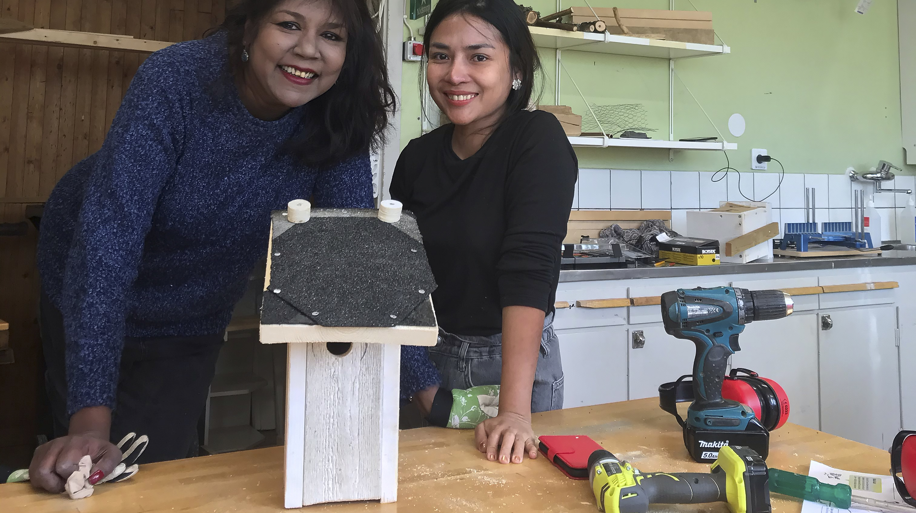 Två deltagare visar upp sin fågelholk, som är byggd av spillvirke