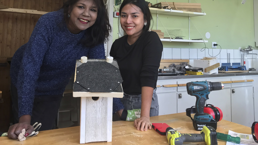 Två deltagare visar upp sin fågelholk, som är byggd av spillvirke