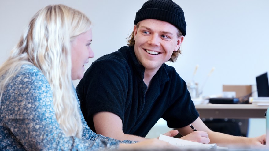 Två deltagare som samtalar och ler.
