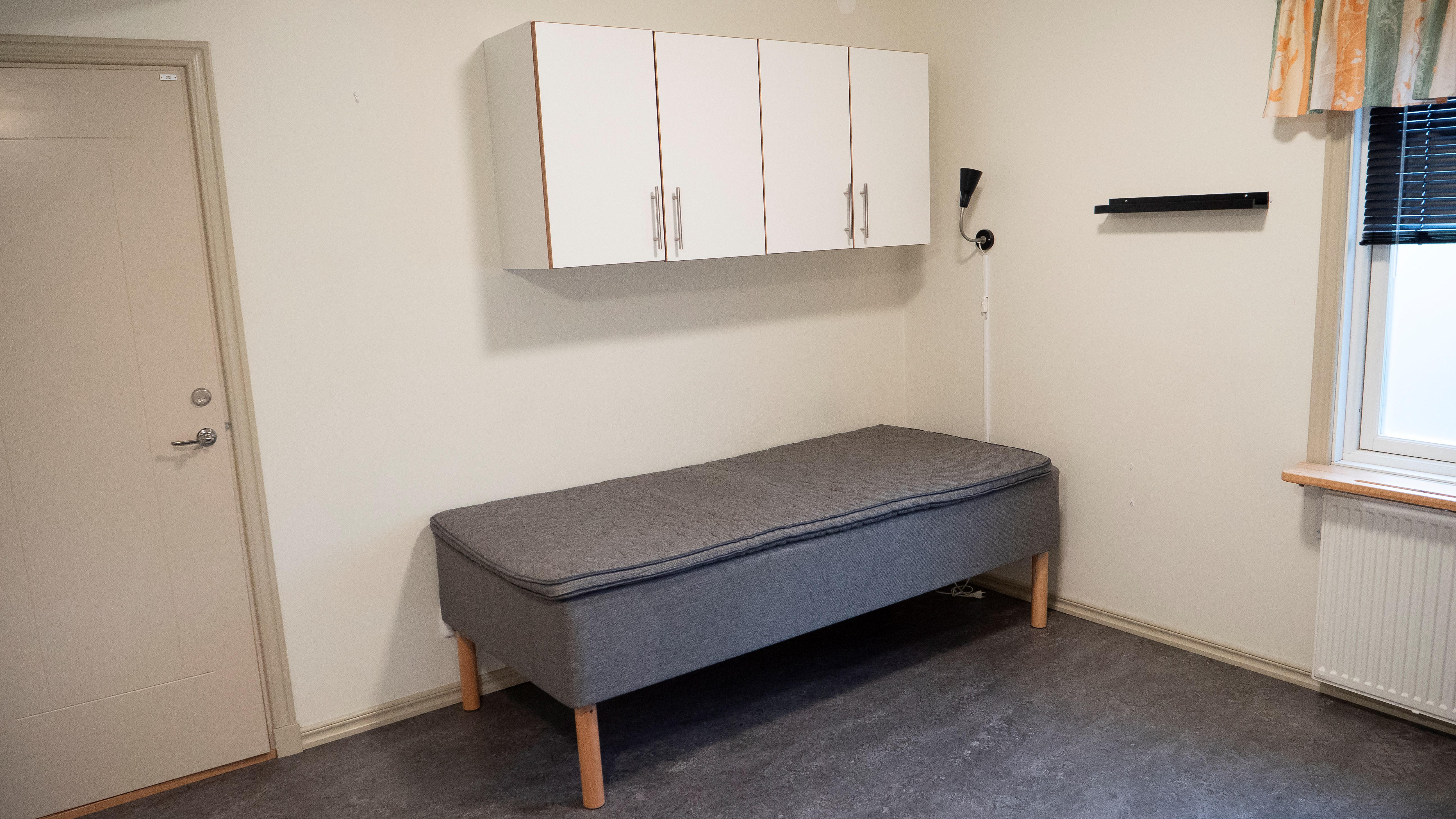 En säng med fyra stycken skåp över.