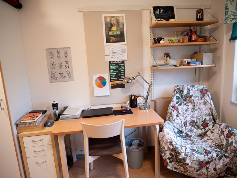 Skrivbord, fåtölj och hylla, litet enkelrum Nybo.